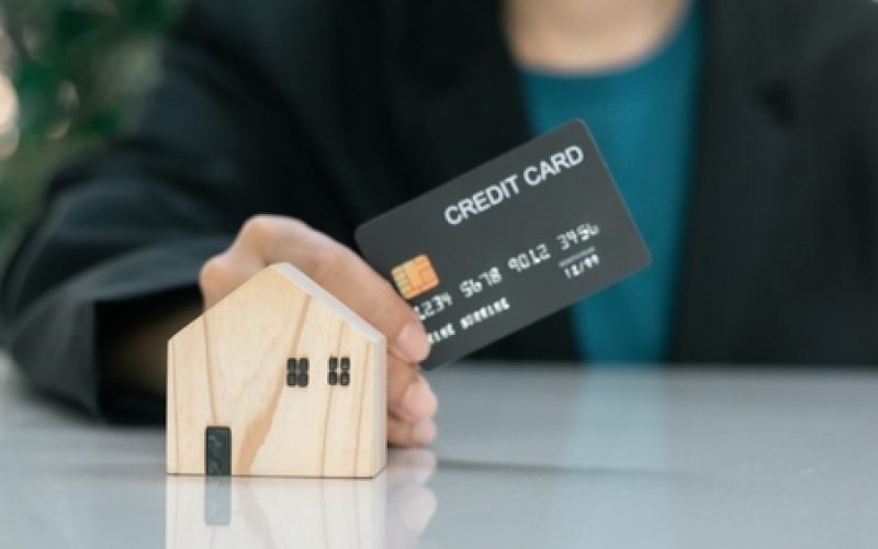 Real,Estate,Concept.,Businessman,Hold,Credit,Card,With,Wooden,House.